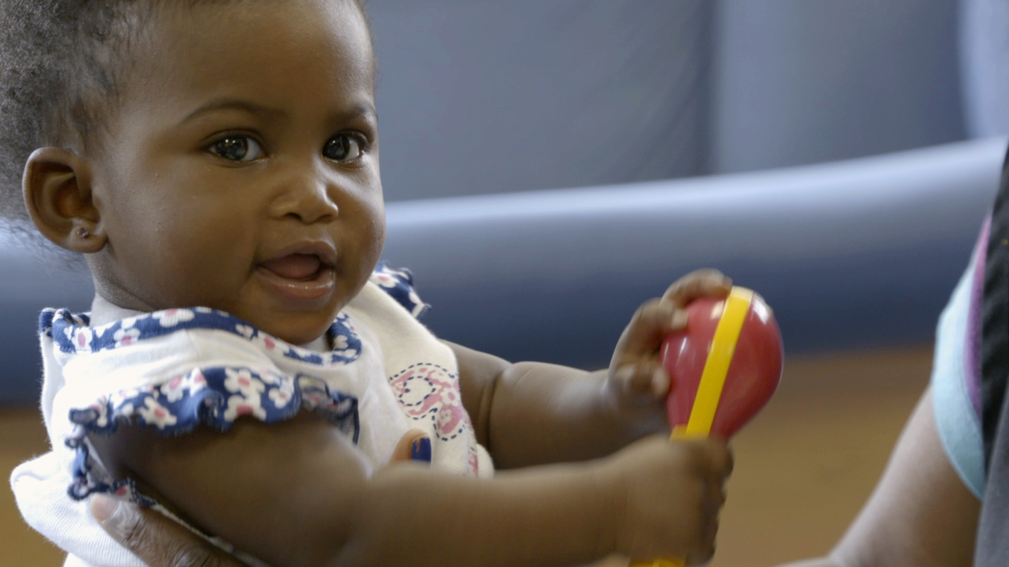 A girl plays in the infant room at Sheltering Arms.